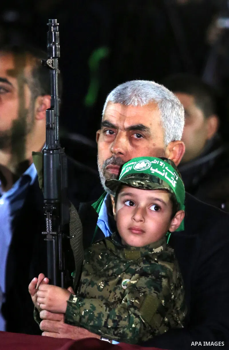 Yahya Sinwar, the new leader of Hamas in the Gaza Strip carries the son of Hamas official, Mazen Faqha, who was shot dead by unknown gunmen during a memorial service in Gaza city on March 27, 2017. Photo by Ashraf Amra