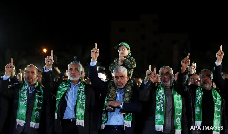 The son of Hamas official, Mazen Faqha, who was shot dead by unknown gunmen sits on the shoulders of Yahya Sinwar, the new leader of Hamas in the Gaza Strip during a memorial service in Gaza city on March 27, 2017. Photo...
