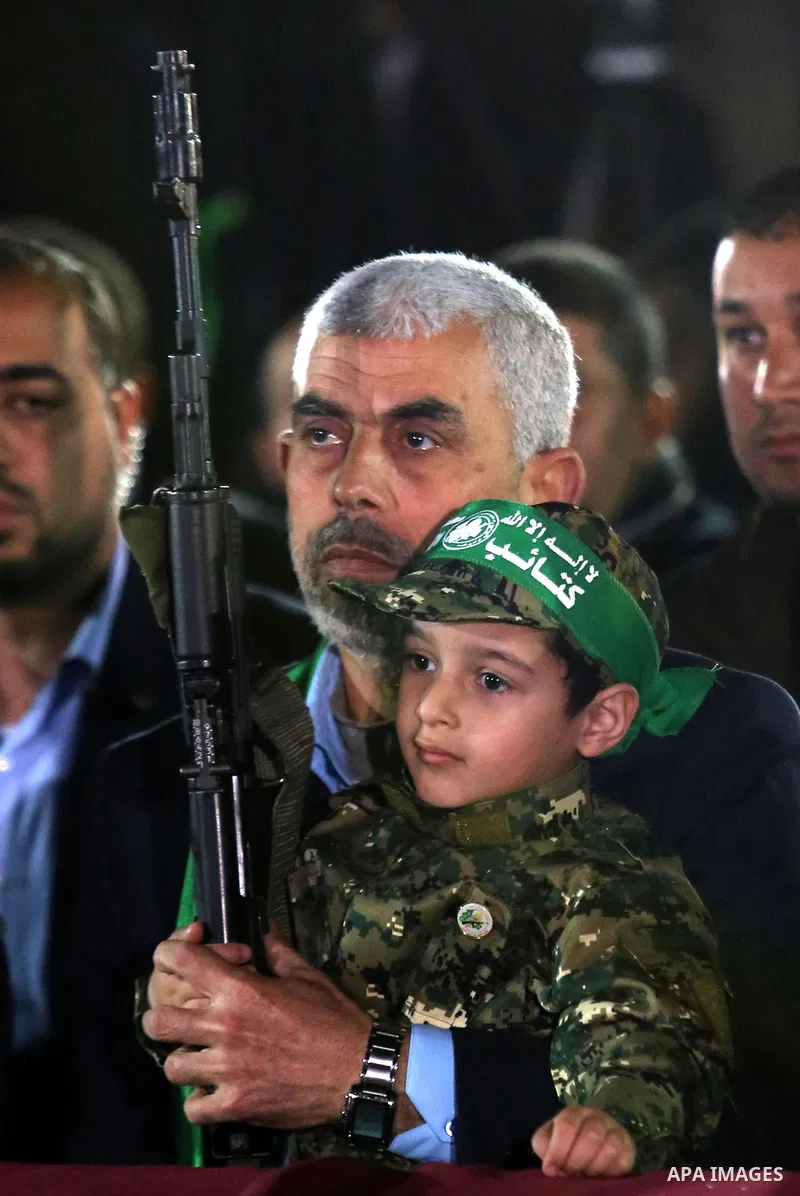 Yahya Sinwar, the new leader of Hamas in the Gaza Strip carries the son of Hamas official, Mazen Faqha, who was shot dead by unknown gunmen during a memorial service, in Gaza city on March 27, 2017. Photo by Ashraf Amra