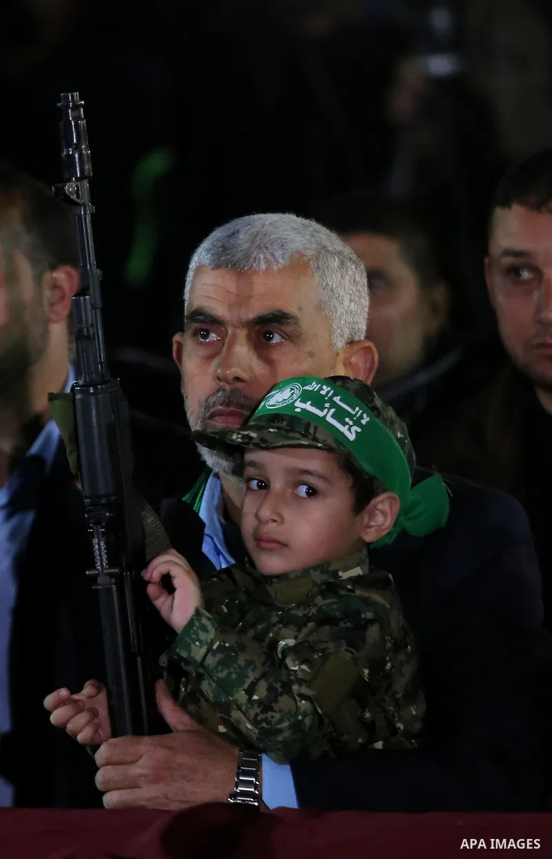 Yahya Sinwar, the new leader of Hamas in the Gaza Strip carries the son of Hamas official, Mazen Faqha, who was shot dead by unknown gunmen during a memorial service, in Gaza city on March 27, 2017. Photo by Ashraf Amra
