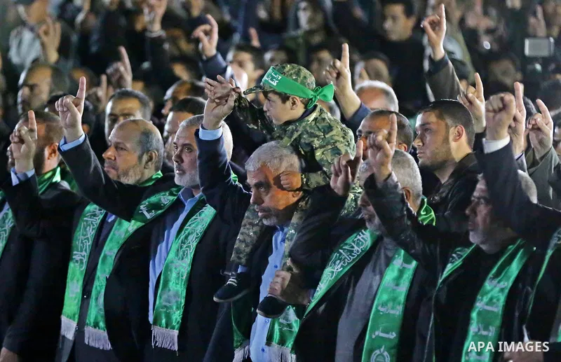 The son of Hamas official, Mazen Faqha, who was shot dead by unknown gunmen sits on the shoulders of Yahya Sinwar, the new leader of Hamas in the Gaza Strip during a memorial service in Gaza city on March 27, 2017. Photo...