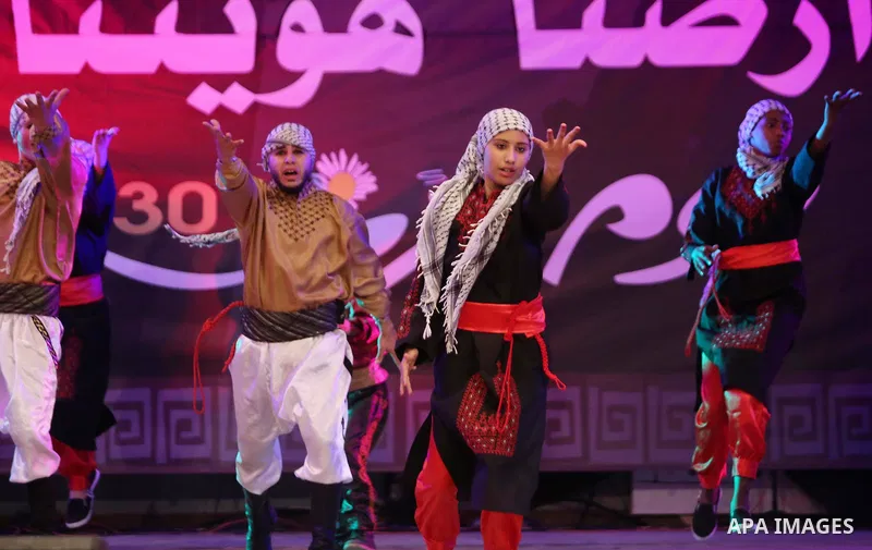Palestinian youths perform a traditional dance during a festival titled "our land..our identity" marking the Land day in Gaza city on March 29, 2017. Photo by Ashraf Amra