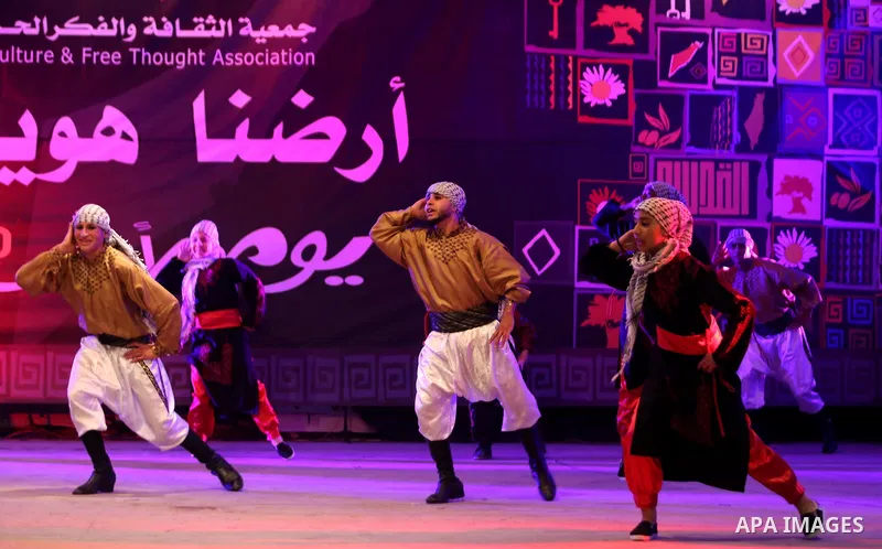 Palestinian youths perform a traditional dance during a festival titled "our land..our identity" marking the Land day in Gaza city on March 29, 2017. Photo by Ashraf Amra