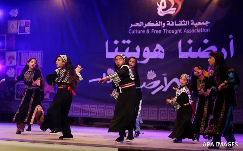 Palestinian children perform a traditional dance during a festival titled "our land..our identity" marking the Land day in Gaza city on March 29, 2017. Photo by Ashraf Amra