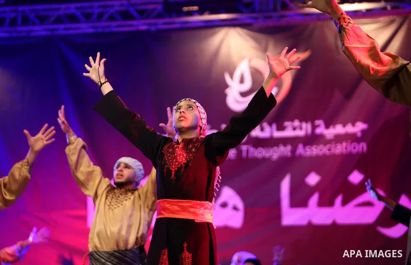 Palestinian youths perform a traditional dance during a festival titled "our land..our identity" marking the Land day in Gaza city on March 29, 2017. Photo by Ashraf Amra