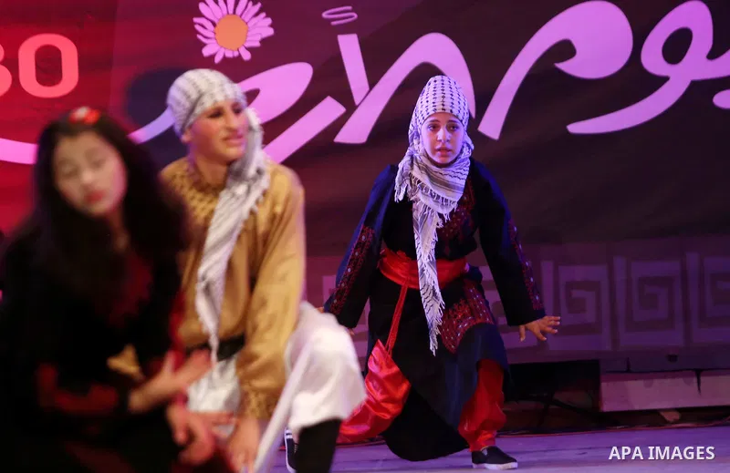 Palestinian youths perform a traditional dance during a festival titled "our land..our identity" marking the Land day in Gaza city on March 29, 2017. Photo by Ashraf Amra