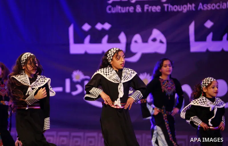 Palestinian children perform a traditional dance during a festival titled "our land..our identity" marking the Land day in Gaza city on March 29, 2017. Photo by Ashraf Amra