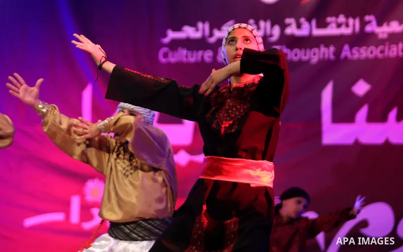 Palestinian youths perform a traditional dance during a festival titled "our land..our identity" marking the Land day in Gaza city on March 29, 2017. Photo by Ashraf Amra