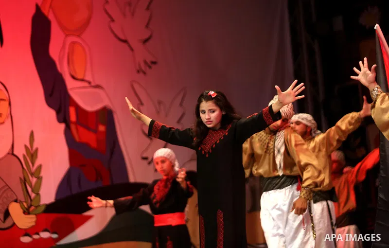 Palestinian youths perform a traditional dance during a festival titled "our land..our identity" marking the Land day in Gaza city on March 29, 2017. Photo by Ashraf Amra