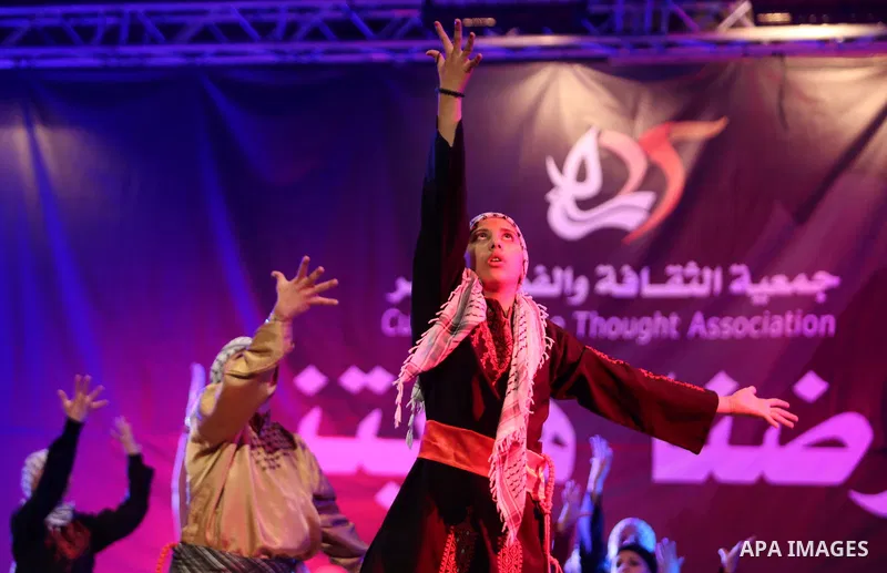 Palestinian youths perform a traditional dance during a festival titled "our land..our identity" marking the Land day in Gaza city on March 29, 2017. Photo by Ashraf Amra