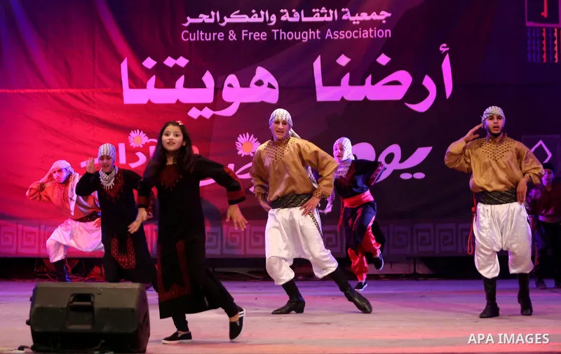 Palestinian youths perform a traditional dance during a festival titled "our land..our identity" marking the Land day in Gaza city on March 29, 2017. Photo by Ashraf Amra