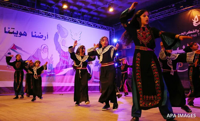 Palestinian children perform a traditional dance during a festival titled "our land..our identity" marking the Land day in Gaza city on March 29, 2017. Photo by Ashraf Amra