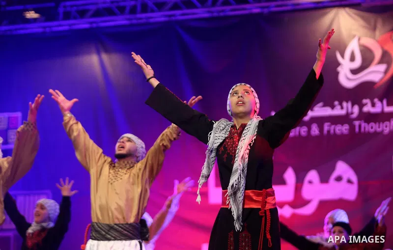 Palestinian youths perform a traditional dance during a festival titled "our land..our identity" marking the Land day in Gaza city on March 29, 2017. Photo by Ashraf Amra