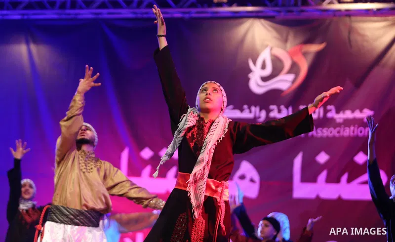 Palestinian youths perform a traditional dance during a festival titled "our land..our identity" marking the Land day in Gaza city on March 29, 2017. Photo by Ashraf Amra