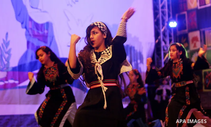 Palestinian children perform a traditional dance during a festival titled "our land..our identity" marking the Land day in Gaza city on March 29, 2017. Photo by Ashraf Amra