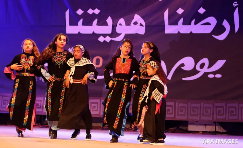 Palestinian children perform a traditional dance during a festival titled "our land..our identity" marking the Land day in Gaza city on March 29, 2017. Photo by Ashraf Amra