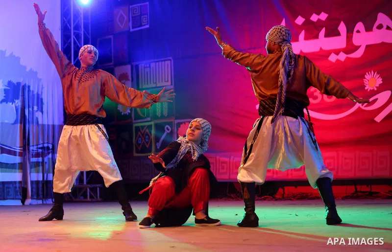 Palestinian youths perform a traditional dance during a festival titled "our land..our identity" marking the Land day in Gaza city on March 29, 2017. Photo by Ashraf Amra