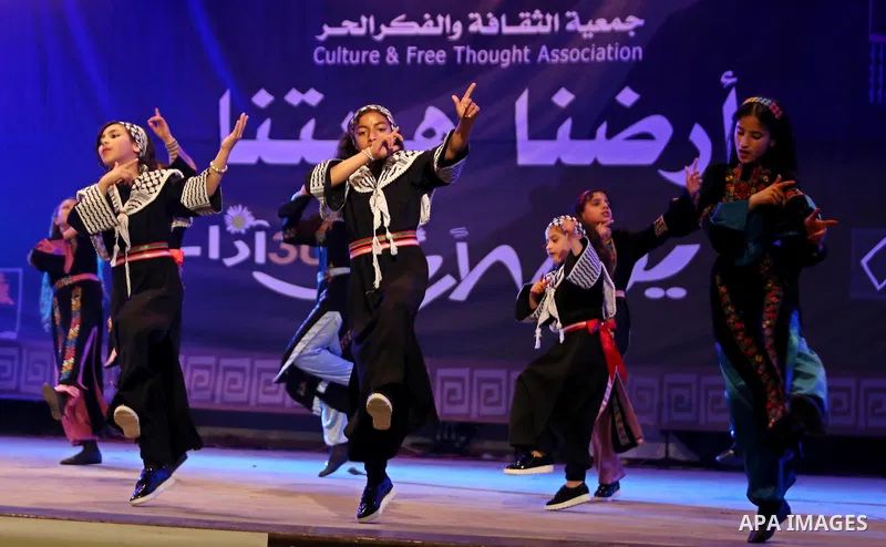 Palestinian children perform a traditional dance during a festival titled "our land..our identity" marking the Land day in Gaza city on March 29, 2017. Photo by Ashraf Amra