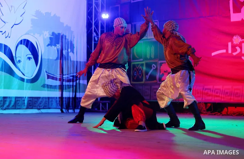 Palestinian youths perform a traditional dance during a festival titled "our land..our identity" marking the Land day in Gaza city on March 29, 2017. Photo by Ashraf Amra