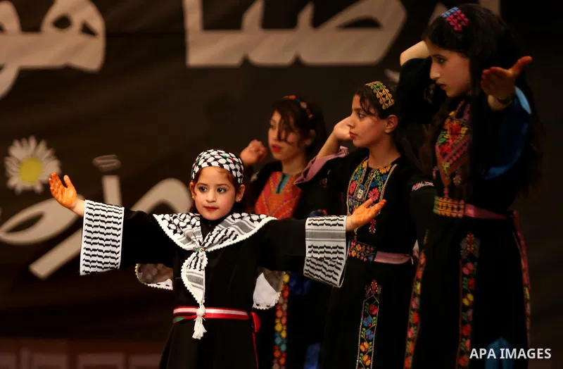 Palestinian children perform a traditional dance during a festival titled "our land..our identity" marking the Land day in Gaza city on March 29, 2017. Photo by Ashraf Amra