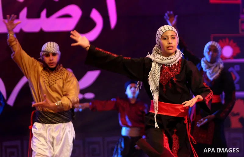 Palestinian youths perform a traditional dance during a festival titled "our land..our identity" marking the Land day in Gaza city on March 29, 2017. Photo by Ashraf Amra
