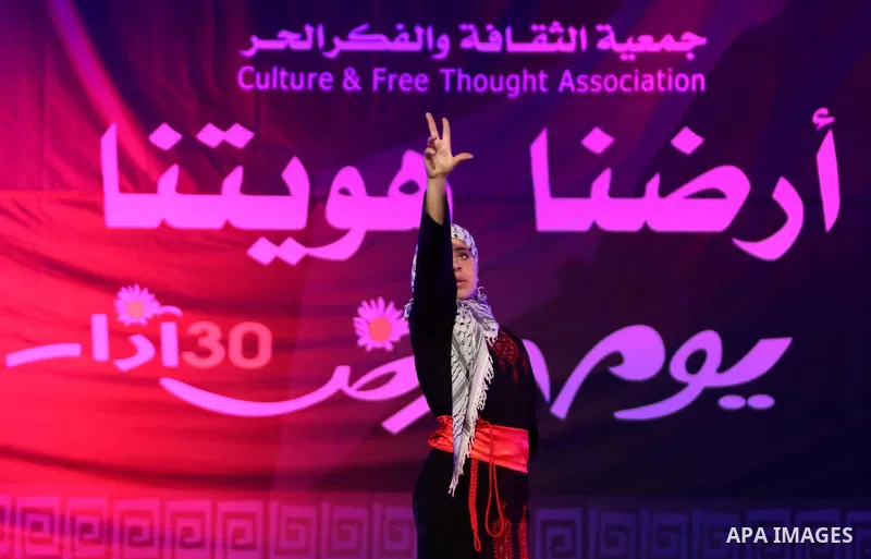 Palestinian youths perform a traditional dance during a festival titled "our land..our identity" marking the Land day in Gaza city on March 29, 2017. Photo by Ashraf Amra
