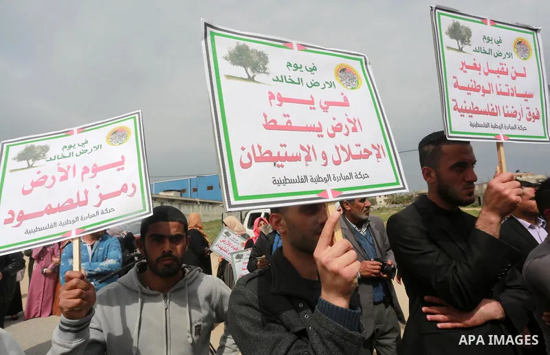 Palestinians hold banners and Palestine flags during a rally marking Land Day, near the Israeli border with northern Gaza Strip March 30, 2017. March 30 marks Land Day, the annual commemorations of the killing by police...