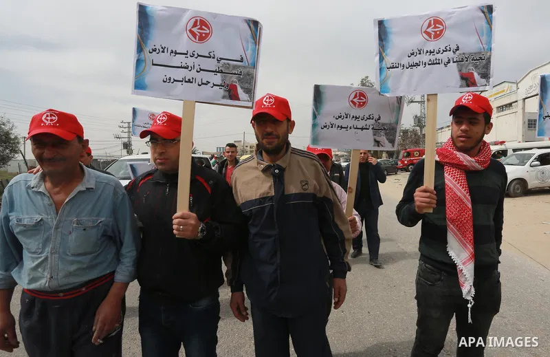 Palestinians hold banners and Palestine flags during a rally marking Land Day, near the Israeli border with northern Gaza Strip March 30, 2017. March 30 marks Land Day, the annual commemorations of the killing by police...