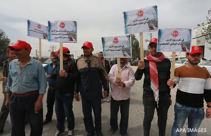 Palestinians hold banners and Palestine flags during a rally marking Land Day, near the Israeli border with northern Gaza Strip March 30, 2017. March 30 marks Land Day, the annual commemorations of the killing by police...