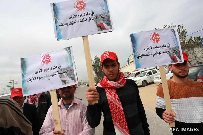 Palestinians hold banners and Palestine flags during a rally marking Land Day, near the Israeli border with northern Gaza Strip March 30, 2017. March 30 marks Land Day, the annual commemorations of the killing by police...