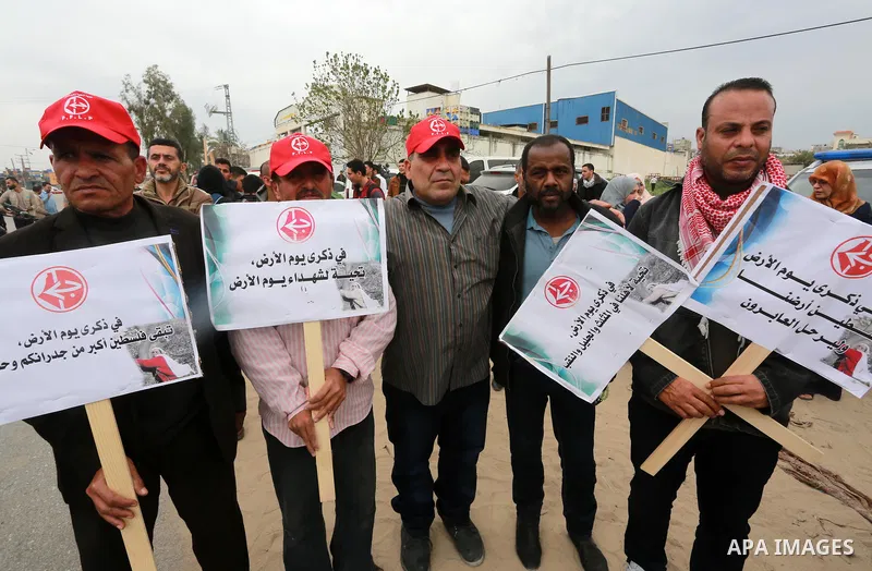 Palestinians hold banners and Palestine flags during a rally marking Land Day, near the Israeli border with northern Gaza Strip March 30, 2017. March 30 marks Land Day, the annual commemorations of the killing by police...