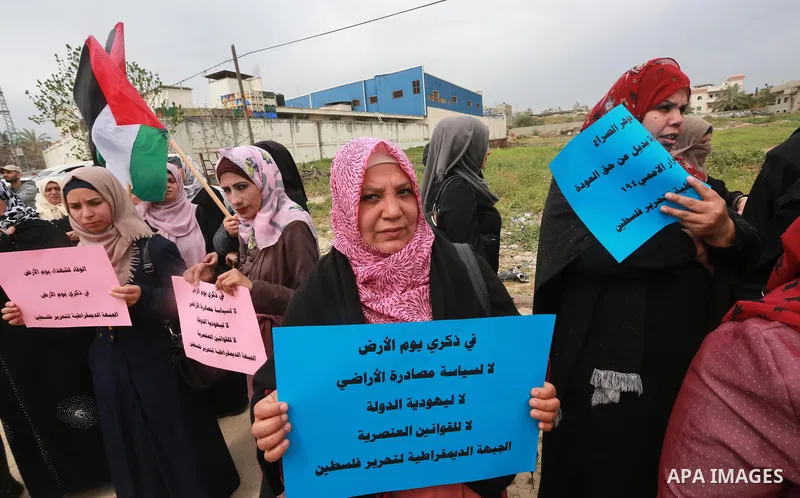 Palestinians hold banners and Palestine flags during a rally marking Land Day, near the Israeli border with northern Gaza Strip March 30, 2017. March 30 marks Land Day, the annual commemorations of the killing by police...