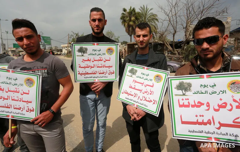 Palestinians hold banners and Palestine flags during a rally marking Land Day, near the Israeli border with northern Gaza Strip March 30, 2017. March 30 marks Land Day, the annual commemorations of the killing by police...