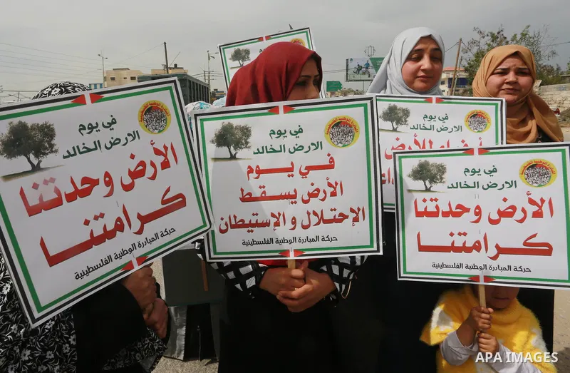 Palestinians hold banners and Palestine flags during a rally marking Land Day, near the Israeli border with northern Gaza Strip March 30, 2017. March 30 marks Land Day, the annual commemorations of the killing by police...