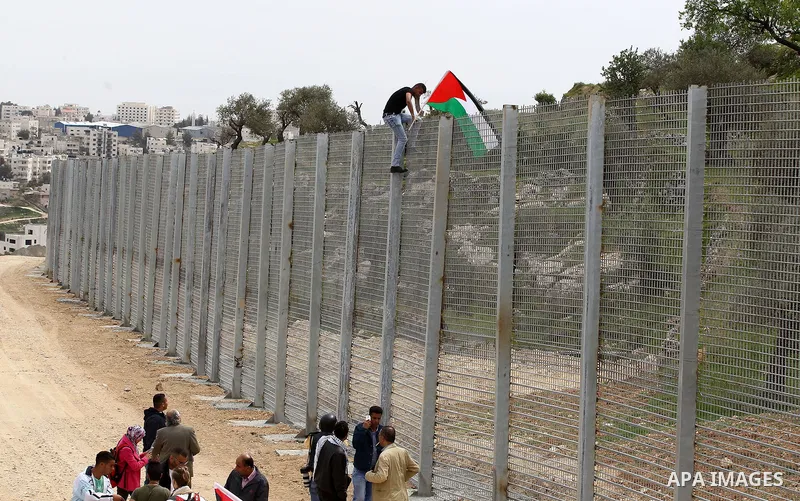 Palestinians hold Palestine flags during a demonstration marking Land Day, in the West Bank city of Beit Jala March 30, 2017. March 30 marks Land Day, the annual commemorations of the killing by police of six Arab citize...