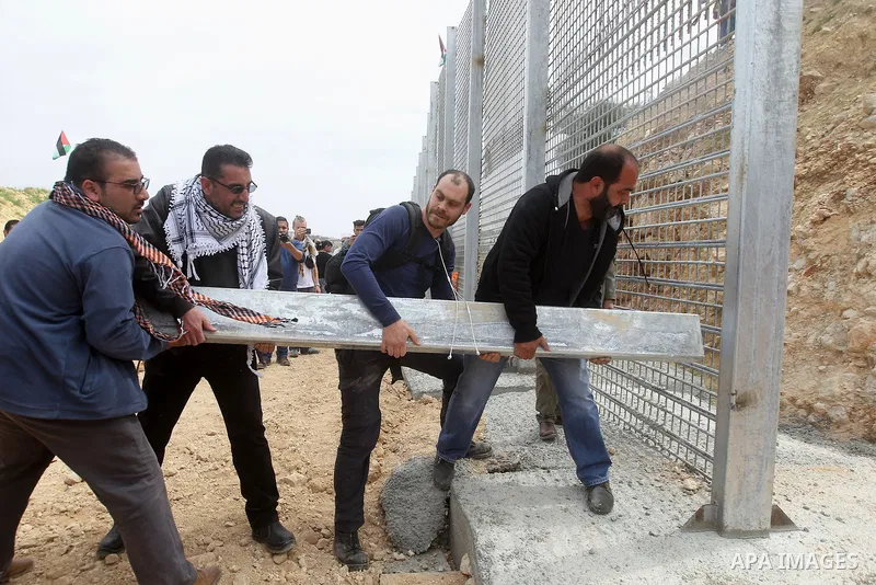 Palestinian demonstrators try to remove a section of the Israeli barrier fence during a protest marking Land Day, in the West Bank city of Beit Jala March 30, 2017. March 30 marks Land Day, the annual commemorations of t...