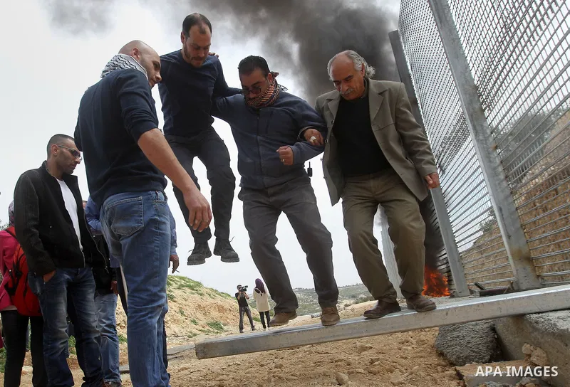 Palestinian demonstrators try to remove a section of the Israeli barrier fence during a protest marking Land Day, in the West Bank city of Beit Jala March 30, 2017. March 30 marks Land Day, the annual commemorations of t...