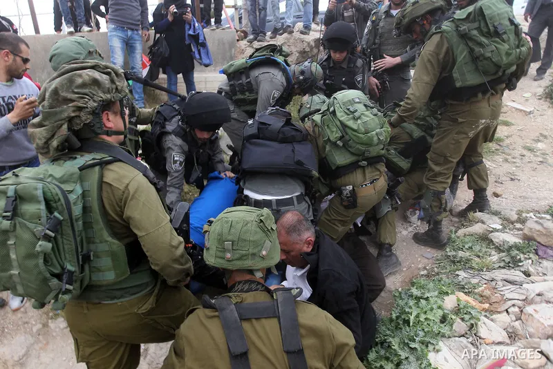 Israeli troops detain a Palestinian demonstrator during a protest marking Land Day in the West Bank city of Hebron March 30, 2017. Photo by Wisam Hashlamoun