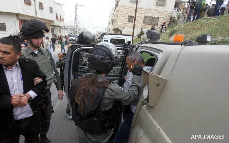 Israeli troops detain a Palestinian demonstrator during a protest marking Land Day in the West Bank city of Hebron March 30, 2017. Photo by Wisam Hashlamoun