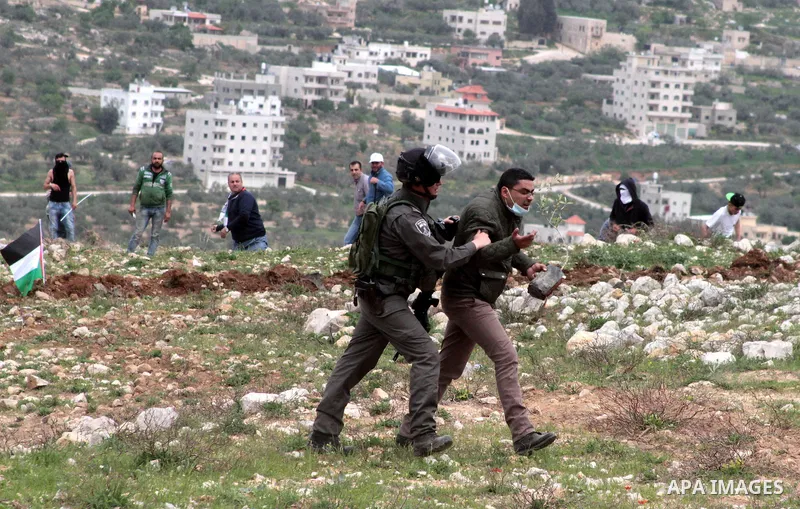 An Israeli solider scuffles with a Palestinian demonstrator during clashes following a protest to mark land day in village of Madama, south of Nablus, on March 30, 2017 in the Israeli occupied West Bank. Land Day marks t...