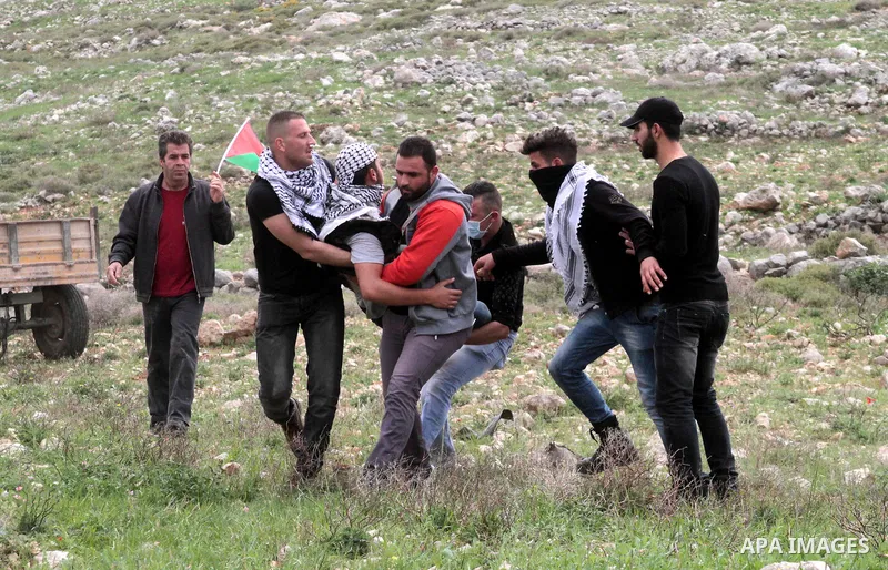 Palestinian demonstrators carry an injured man during clashes with Israeli forces following a protest to mark land day in village of Madama, south of Nablus, on March 30, 2017 in the Israeli occupied West Bank. Land Day...
