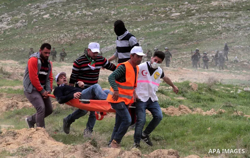 Palestinian demonstrators carry an injured man during clashes with Israeli forces following a protest to mark land day in village of Madama, south of Nablus, on March 30, 2017 in the Israeli occupied West Bank. Land Day...