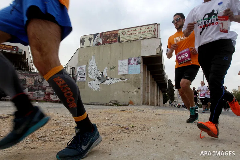 Participants run in the biblical West Bank town of Bethlehem during the 5th Palestine Marathon on March 31, 2017. Photo by Wisam Hashlamoun