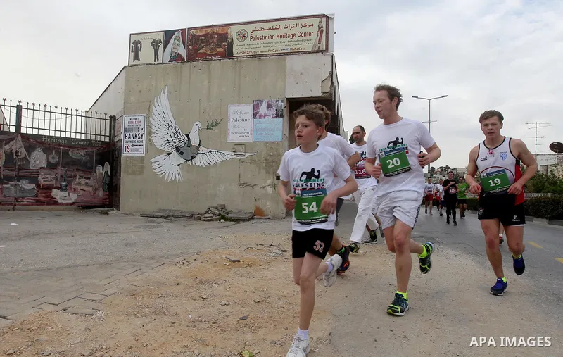 Participants run in the biblical West Bank town of Bethlehem during the 5th Palestine Marathon on March 31, 2017. Photo by Wisam Hashlamoun