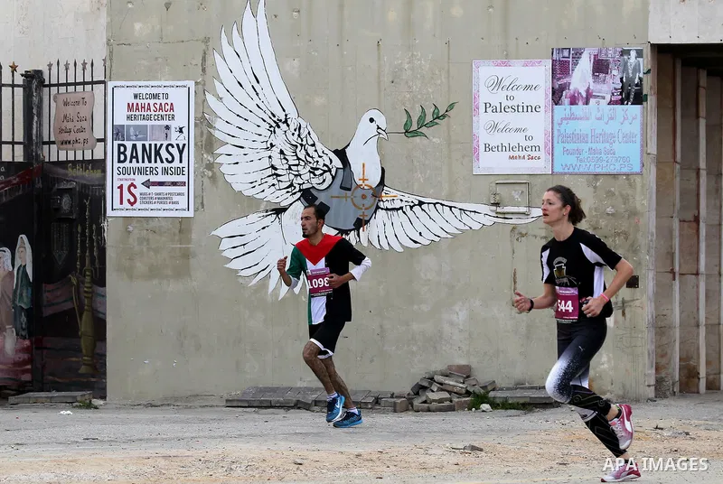 Participants run in the biblical West Bank town of Bethlehem during the 5th Palestine Marathon on March 31, 2017. Photo by Wisam Hashlamoun