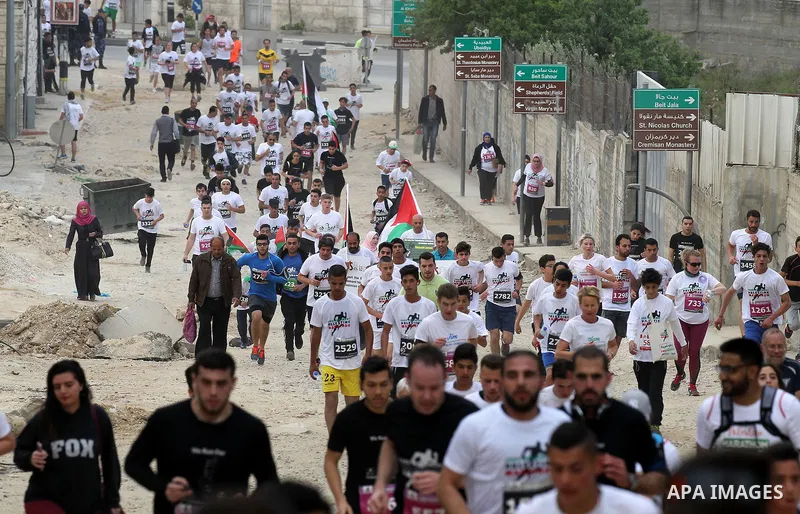 Participants run in the biblical West Bank town of Bethlehem during the 5th Palestine Marathon on March 31, 2017. Photo by Wisam Hashlamoun