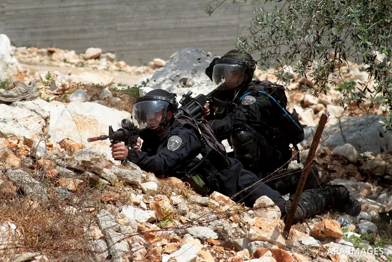 Israeli security forces aim their weapons towards Palestinian protesters during clashes following a weekly demonstration against the expropriation of Palestinian land by Israel in the village of Kfar Qaddum, near Nablus,...