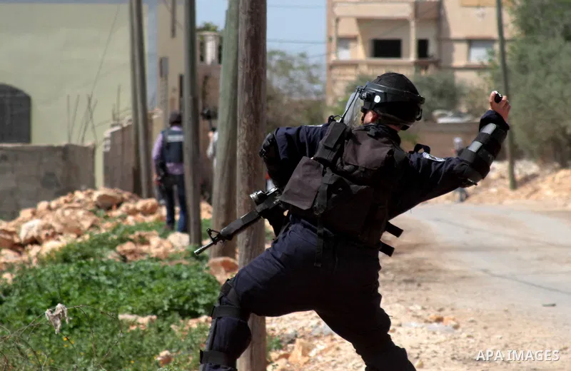 A member of Israeli security forces fires a tear gas canister towards Palestinian protesters during clashes following a weekly demonstration against the expropriation of Palestinian land by Israel in the village of Kfar...