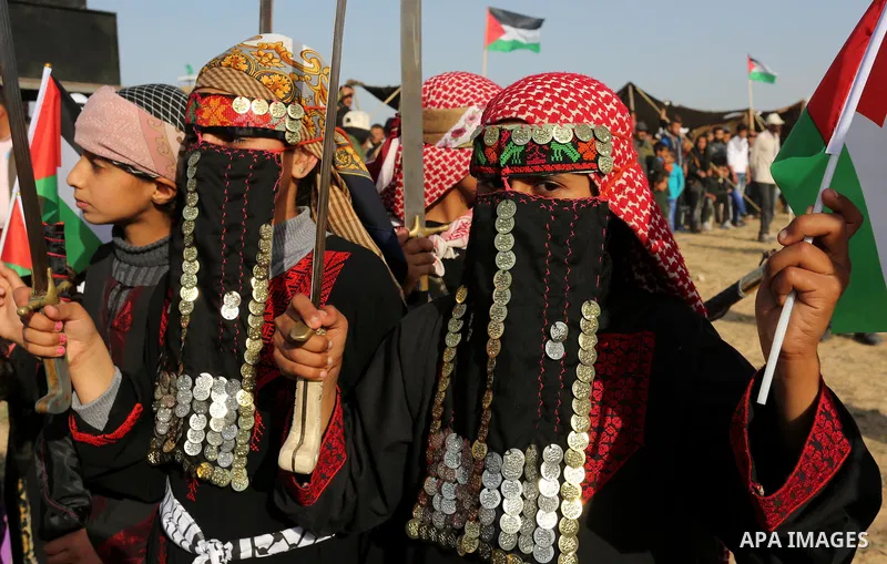 Palestinian bedouin girls wear traditional dress and hold swords during a rally marking the 41st anniversary of Land Day, in Deir el-Balah, Central Gaza Strip, on March 31, 2017. Land Day marks the killing of six Arab Is...