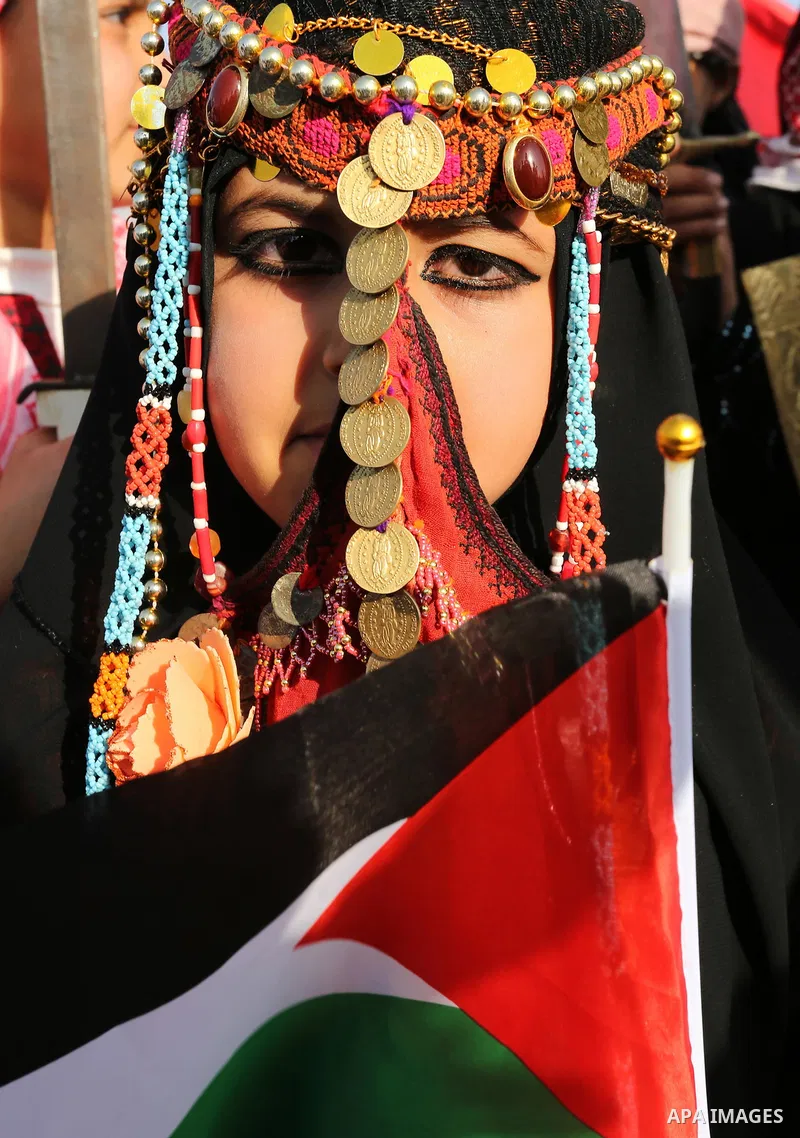 A Palestinian bedouin girl wears traditional dress and poses for a photo during a rally marking the 41st anniversary of Land Day, in Deir el-Balah, Central Gaza Strip, on March 31, 2017. Land Day marks the killing of six...